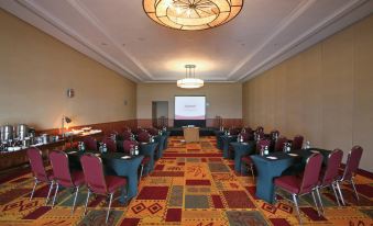 a conference room with rows of chairs arranged in a semicircle , and a projector screen mounted on the wall at Venezuela Marriott Hotel Playa Grande