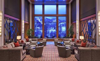 a large room with multiple couches and chairs arranged in front of a large window at The Westin Riverfront Resort & Spa, Avon, Vail Valley