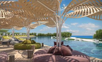 a poolside area with a large wooden canopy and various couches , chairs , and umbrellas , providing a relaxing atmosphere at The Ivi Mare - Designed for Adults by Louis Hotels