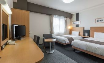 a modern hotel room with two beds , a desk , and a chair , all arranged neatly at Comfort Hotel Koriyama