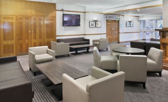 a well - lit waiting room with several couches and chairs arranged in a seating area , creating a comfortable atmosphere for guests at Holiday Inn Washington