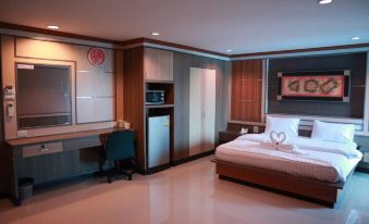 a modern hotel room with a bed , desk , and kitchenette , along with chinese characters on the wall at Phetlada Pavilion & Resort