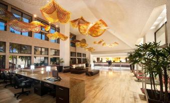a modern hotel lobby with a reception desk and chairs , as well as gold decorations at El Cid Marina Beach Hotel