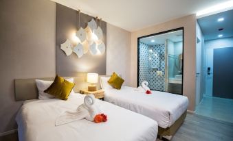 a modern hotel room with two beds , a white bedspread , and gold pillows , as well as a modern light fixture hanging from the ceiling at Villa Baron