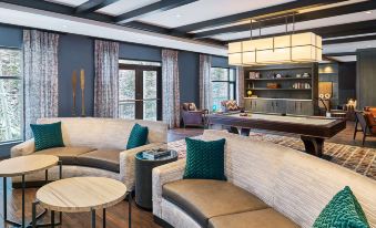 a modern living room with a large sectional couch , wooden coffee table , and a bar area at Grand Hyatt Vail