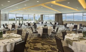 a large dining room with tables and chairs set up for a formal event , possibly a wedding reception at Element Vancouver Metrotown