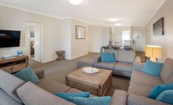 a living room with two couches and a coffee table in the middle , surrounded by chairs at Broadwater Resort Como