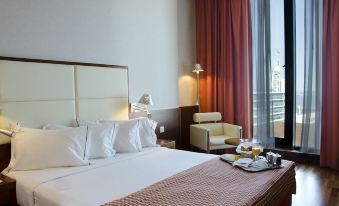 The bedroom features a double bed and a large window that overlooks the restaurant at VIP Executive Arts Hotel