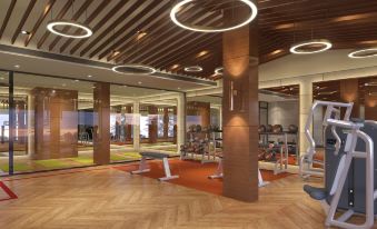 a modern gym with wooden floors , large windows , and an orange floor is illuminated by circular lights at Sheraton Kosgoda Turtle Beach Resort