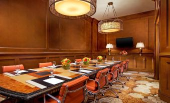 a long conference table with orange chairs , black place mats , and flowers in the center at 1 Hotel Hanalei Bay