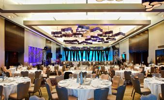 a large banquet hall with numerous tables and chairs set up for a formal event at Doubletree by Hilton Montreal