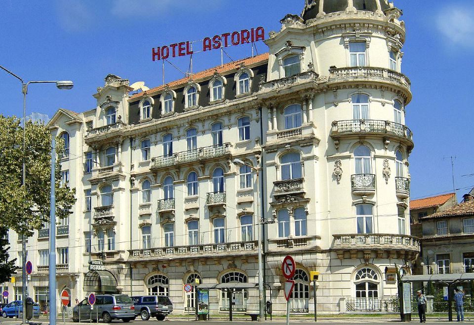 "a large , ornate hotel building with a red sign that reads "" hotel astoria "" prominently displayed on the front" at Hotel Astoria