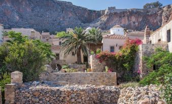 a picturesque village with stone buildings , palm trees , and a view of a mountain in the background at Casa Palma