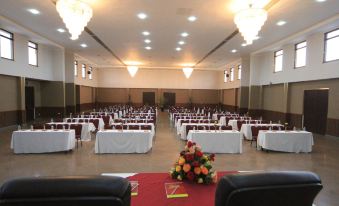 a large , empty banquet hall with rows of tables and chairs set up for a formal event at Haile Resort Hawassa