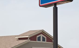 a blue sign for the americinn lodge & suites is displayed in front of a building at AmericInn by Wyndham Anamosa