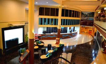 a hotel lobby with a reception desk , chairs , and a large clock on the wall at De Rhu Beach Resort