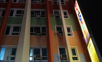 a colorful building with multiple windows and air conditioning units is lit up at night at My Hotel