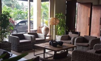 a well - lit room with several couches and chairs arranged in a seating area , creating a cozy atmosphere at Hotel Grand Papua Kaimana