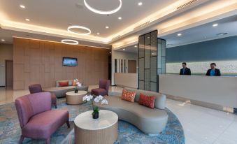 a modern and stylish waiting room with comfortable seating , a reception desk , and a business card at Citadines DPulze Cyberjaya
