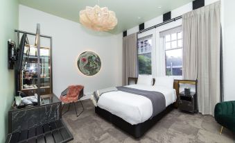 a modern bedroom with a large bed , a chair , and a rug on the floor at Clarence Boutique Hotel