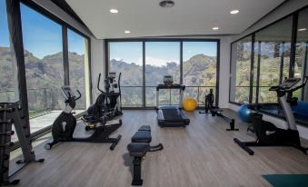 a well - equipped gym with a variety of exercise equipment , including treadmills , weight machines , and free weights at Eira do Serrado - Hotel & Spa