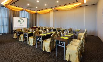 a conference room set up for a meeting , with tables and chairs arranged in rows at Kip Hotel
