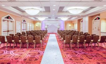 a large conference room with rows of chairs arranged in a semicircle , ready for an event at Crowne Plaza Englewood, an IHG Hotel