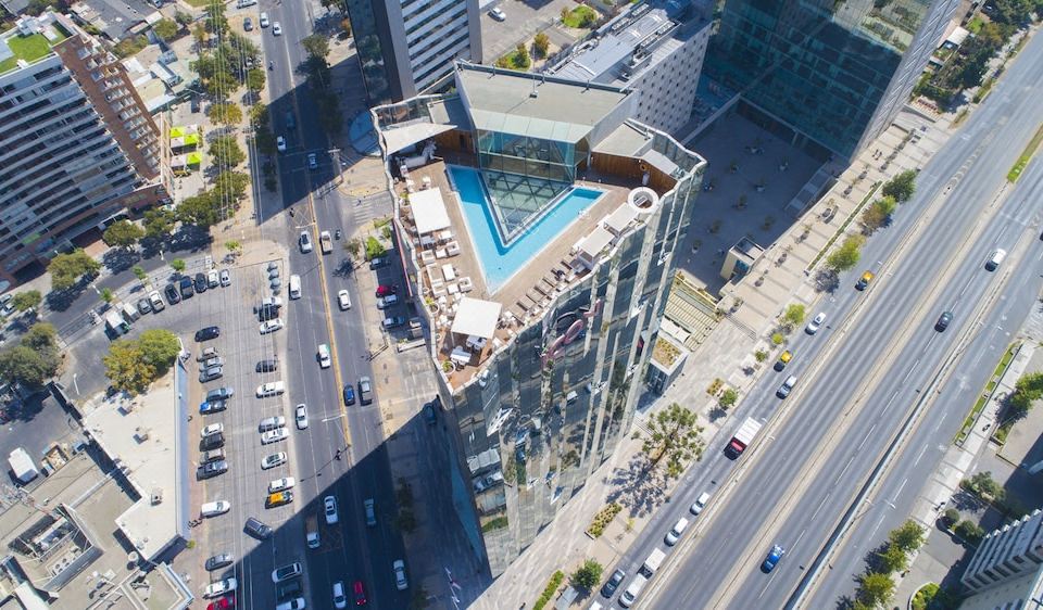 an aerial view of a modern building with a swimming pool , surrounded by busy city streets and traffic at Icon Hotel