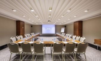 a conference room with a long table and chairs , a projector screen , and recessed lighting at DoubleTree by Hilton Istanbul-Avcilar