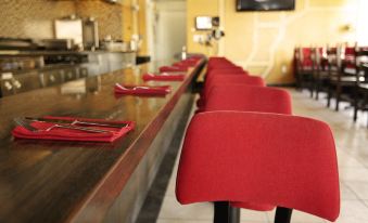 a row of red chairs is lined up in front of a long wooden counter at The Dixie Hollywood