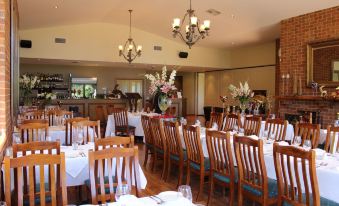 a large dining room with wooden tables and chairs arranged for a group of people to enjoy a meal together at Wild Cattle Creek Estate
