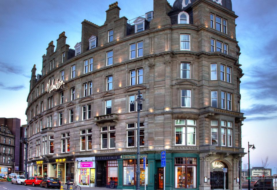 a large , ornate building with multiple levels and balconies is located on a street corner at Malmaison Dundee