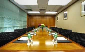 The hotel offers a spacious conference room equipped with wooden tables and brown chairs, suitable for hosting meetings and corporate events at The Charterhouse Causeway Bay