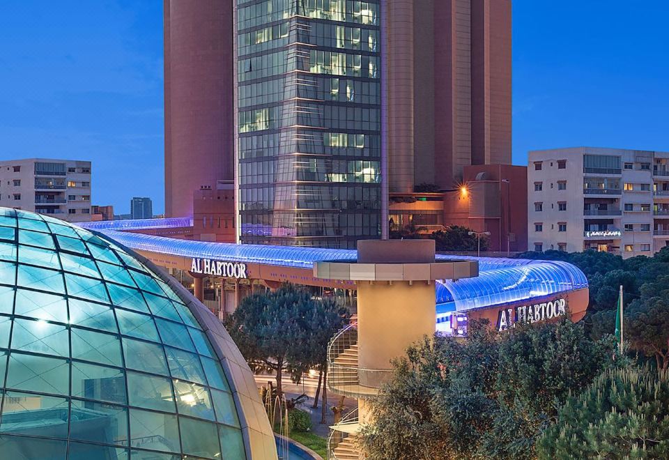 a modern building with a glass dome and a large glass dome in front of it at Hilton Beirut Metropolitan Palace