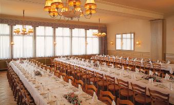a large , elegant dining room with long tables and chairs arranged for a formal event at Hotel Weisses Kreuz