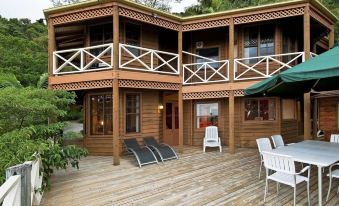 a wooden deck with multiple lounge chairs and a dining table , providing a comfortable outdoor setting at Treetops Montville