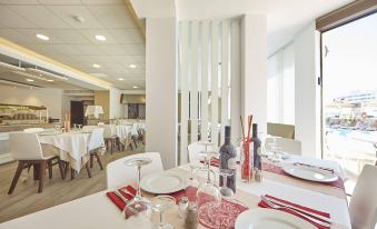 a dining room with tables set for a meal , featuring white plates and red napkins at Hotel Principe Wellness&Spa