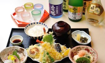 a dining table with a variety of dishes and utensils , including bowls , cups , and bottles at Hiroshima Airport Hotel