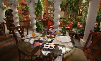 a dining table with a variety of food items , including fruits and desserts , placed on it at Sacred House