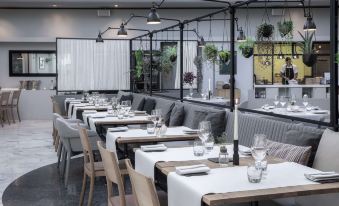 a modern dining room with wooden tables and chairs , white tablecloths , and hanging lamps , creating an inviting atmosphere at Radisson Blu Scandinavia Hotel, Aarhus