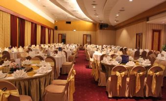 a large banquet hall filled with tables and chairs , ready for a formal event or wedding reception at Chon Inter Hotel