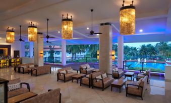 a luxurious hotel lobby with multiple couches , chairs , and tables , creating a comfortable and inviting atmosphere at Holiday Inn Resort Goa