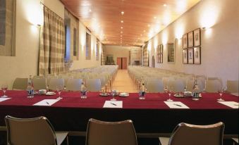 a conference room set up for a meeting , with tables and chairs arranged in rows at Parador de Santo Estevo