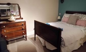 a well - decorated bedroom with a large bed , wooden dresser , and a mirror on the wall at Bulls Head