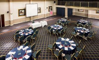 a large banquet hall with multiple round tables set up for a formal event , possibly a wedding reception at Mercure Bristol North the Grange Hotel