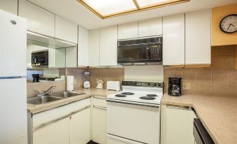 a kitchen with white cabinets , a stove , and a microwave oven under a skylight above at Legacy Vacation Resorts-Indian Shores