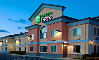 an exterior view of a holiday inn express hotel , with a large sign above the entrance at Holiday Inn Express & Suites Jackson