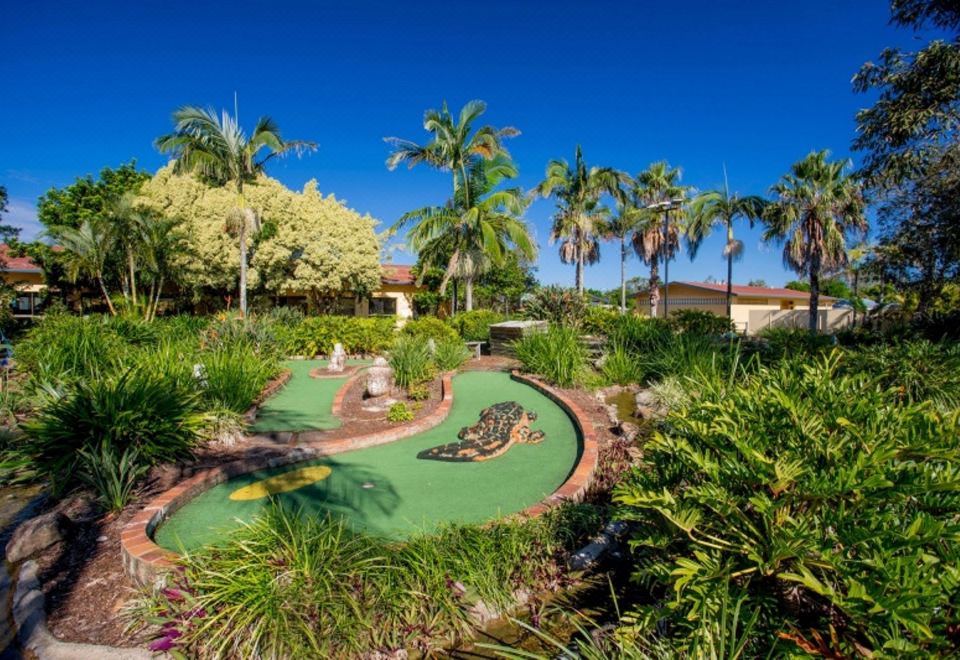 a miniature golf course surrounded by palm trees and lush greenery , creating a picturesque scene at Discovery Parks - Ballina