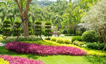 a lush green park with a variety of colorful flowers and trees , creating a picturesque scene at Hotel Cham Cham