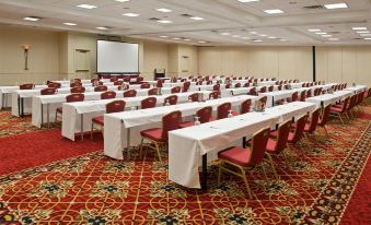 a large conference room with rows of chairs arranged in a semicircle , and a projector screen on the wall at Doubletree by Hilton Columbus Dublin